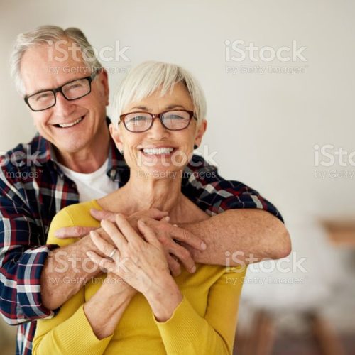 Cropped portrait of a senior man affectionately embracing his wife at home